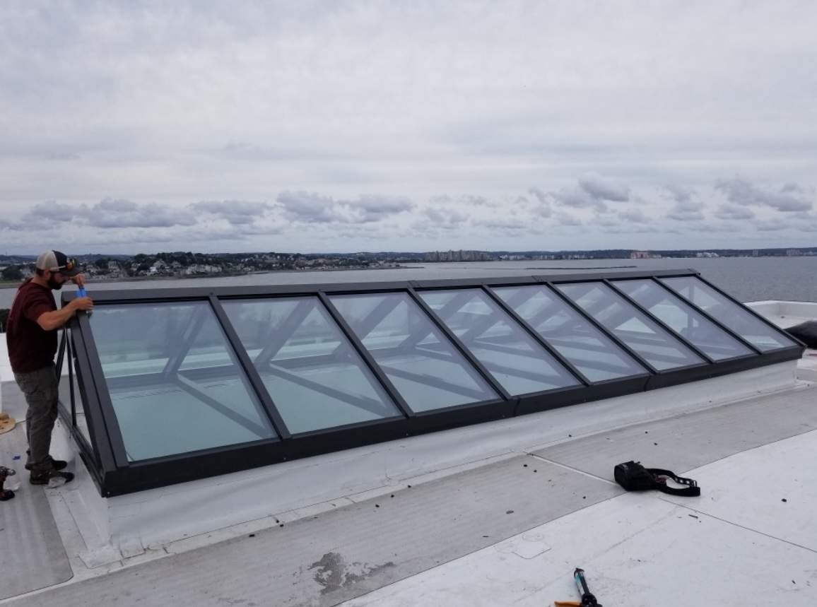 Long VELUX metal-framed commercial skylight spanning a flat roof in Rhode Island