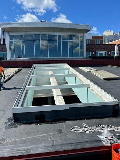 Large VELUX metal-framed commercial skylight mid-installation on a flat roof in Rhode Island, no crew visible