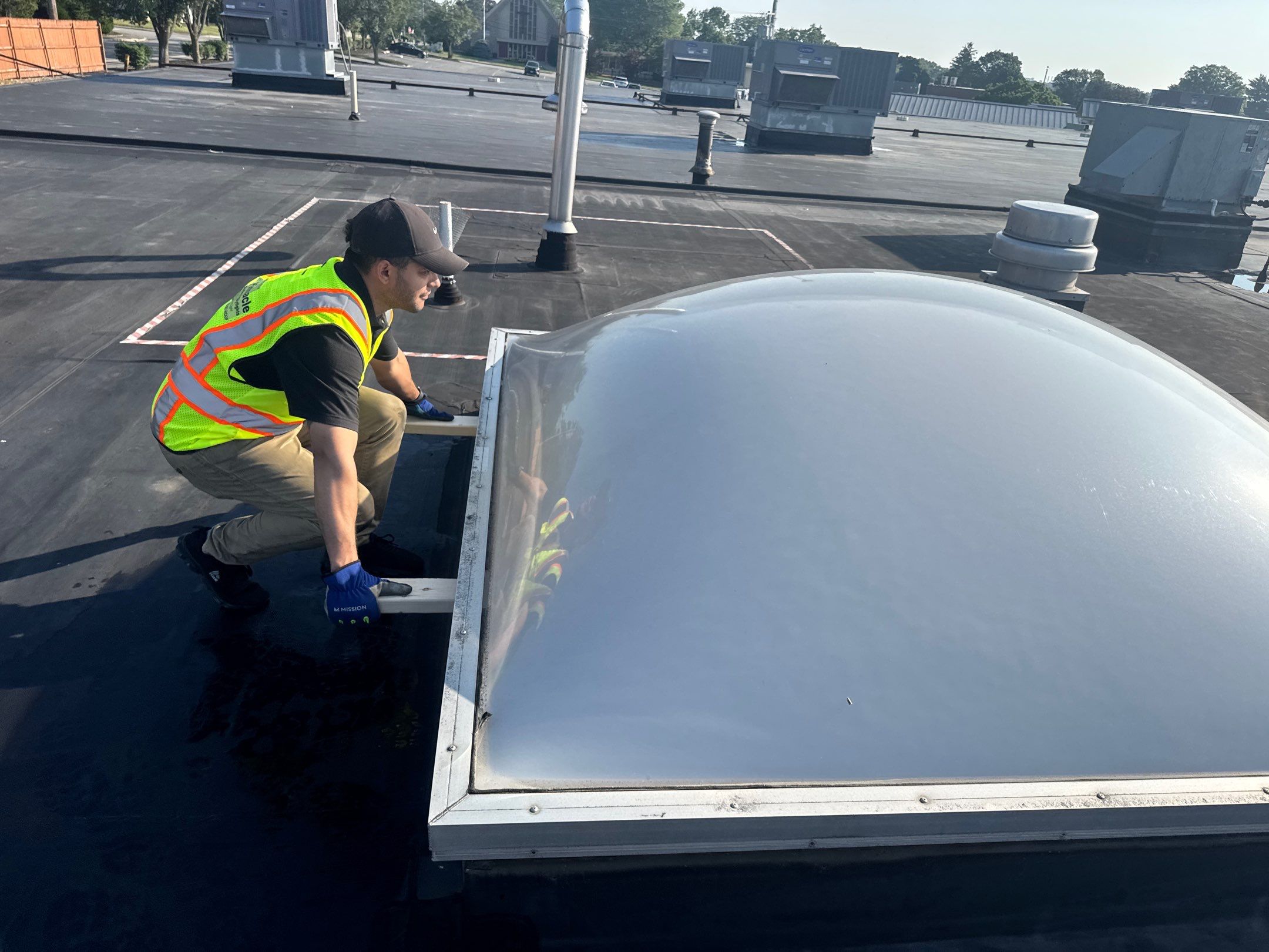 Close-up of a VELUX unit dome skylight with curb and flashing on a flat commercial roof in Rhode Island