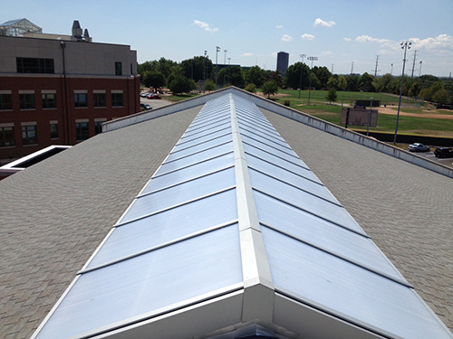 Exterior view of a long, double-pitched VELUX metal-framed ridge t on ae Island commercial building