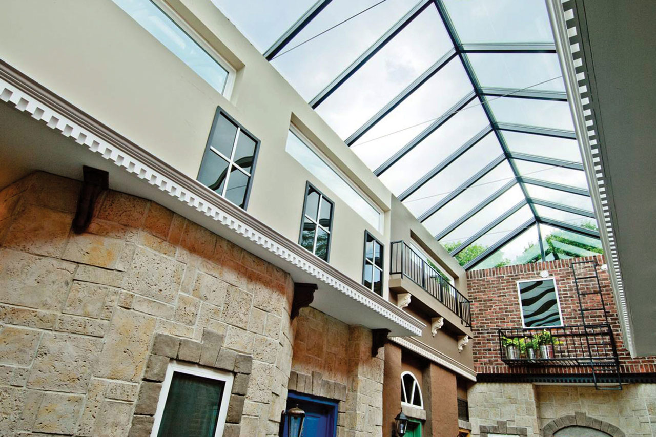 Interior view of a large double-pitched VELUX metal-framed ridge skylight lighting a long hallway in a commercial building